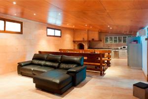 a living room with a leather couch and a kitchen at Sestados in Sa Pobla