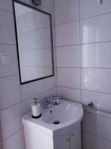 a white bathroom with a sink and a mirror at Apartment Blue - right at the beach in Ilovik