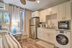 a kitchen with white cabinets and a washer at Ozona Studio with Shared Deck - Steps to Gulf! in Palm Harbor