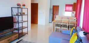 a living room with a tv and a living room with a couch at Новый дом 106 м2, территория 160 м2 и своя парковка in Phuket Town