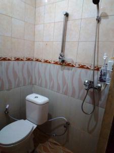 a bathroom with a toilet and a shower at Guest House Dissa in Purwokerto