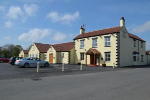 a row of houses with cars parked in a parking lot at The Reindeer Inn in Sandtoft