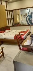 a room with two beds and a table and a chair at Hotel Aston in Kolkata