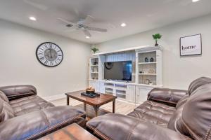 a living room with two leather couches and a tv at Spacious Gulfport Home with Yard 1 Mi to Beach in Gulfport