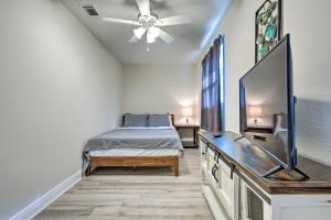 a bedroom with a bed and a flat screen tv at Spacious Gulfport Home with Yard 1 Mi to Beach in Gulfport