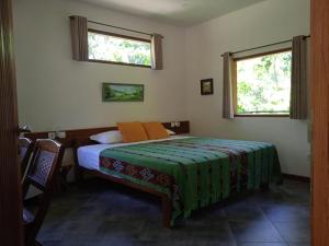 a bedroom with a bed and two windows at The Country House in Senggigi 