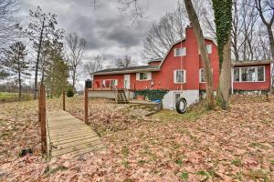 HaslettHome on 10 Acres Perfect for MSU Football Weekend的前面有一座红房子,前面有一座木桥