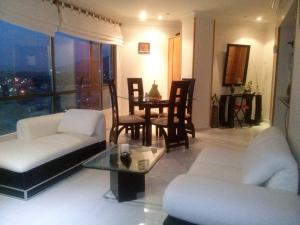 a living room with a white couch and a table at Apartment Bello Horizonte in Santa Marta