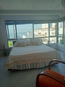 a bedroom with a large bed with a large window at Apartment Bello Horizonte in Santa Marta