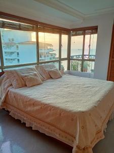 a bedroom with a large bed with a view of the ocean at Apartment Bello Horizonte in Santa Marta