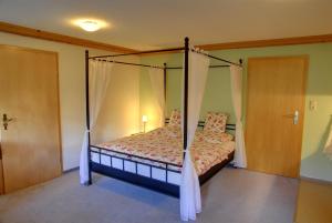 a bedroom with a bed with a canopy at Bergführer-Hüsle in Mittelberg