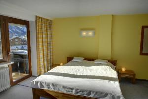 ein Schlafzimmer mit einem Bett und einem großen Fenster in der Unterkunft Bergführer-Hüsle in Mittelberg