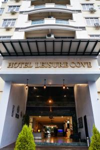 a hotel entrance with a hotel leisure cove sign on it at Leisure Cove Hotel and Apartments in George Town