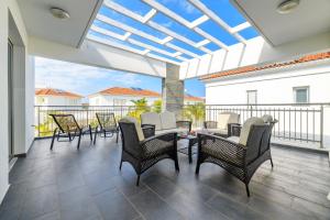 een patio met stoelen en tafels op een balkon bij Blue Pelagos Villa in Protaras