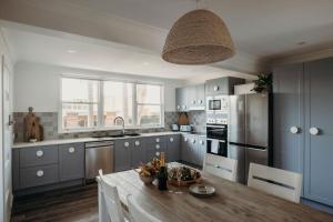 a kitchen with blue cabinets and a wooden table at Nelson Palms in Nelson Bay