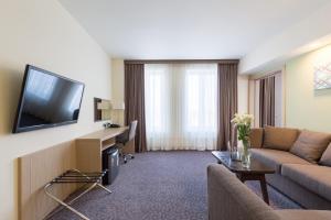 a living room with a couch and a tv at Nesterov Plaza Hotel in Ufa