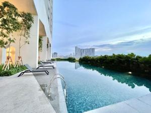 - une piscine avec des chaises à côté d'un bâtiment dans l'établissement UNA Serviced Apartment by Moka, à Kuala Lumpur