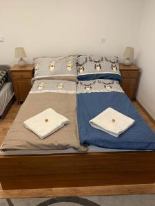 a bed with two pillows and towels on it at Érdi Muskátlis Vendégház in Érd