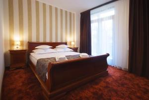 a bedroom with a large bed with a large window at Hotel Moldavia in Slănic-Moldova