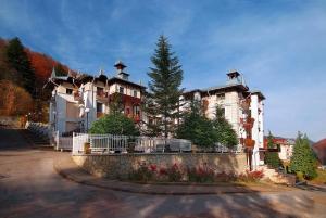 une grande maison avec une clôture devant elle dans l'établissement Hotel Moldavia, à Slănic-Moldova