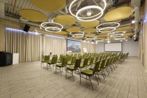 a conference room with green chairs and a screen at Nesterov Plaza Hotel in Ufa