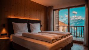 a bedroom with a bed with a view of a mountain at Kierhof Chalets in Velturno