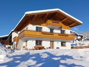 een gebouw met sneeuw op de grond ervoor bij Ferienwohnung Kant in Fieberbrunn