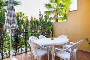 patio ze stołem, krzesłami i parasolem w obiekcie Dorado Playa w mieście Huelva