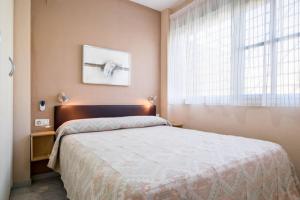 a bedroom with a large bed and a window at Dorado Playa in Isla Cristina +17 photos