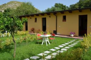 une maison avec une table et des chaises dans la cour dans l'établissement B&B La Torretta, à Gasponi