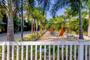 un parque infantil con columpios y palmeras en StayVista at Starry Deck with Pvt Pool & Terrace Access, en Chennai