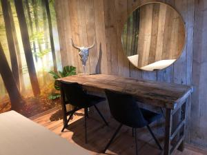 a room with a wooden table with chairs and a mirror at Logement Bilderdam in Leimuiden
