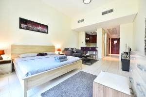 a bedroom with a bed and a living room at Spacious Fully Furnished Studio Apt - Next to Metro, 5 Mins from Mall - TNY in Dubai