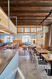 ein Restaurant mit Holztischen und -stühlen und einer Bar in der Unterkunft Landgasthof Linde Hepbach, Hotel & Restaurant in Markdorf