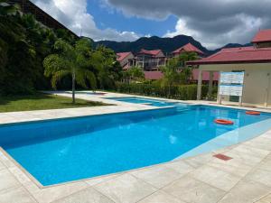 a large blue swimming pool in front of some houses at Eden Island (GIE Apartment) in Eden Island