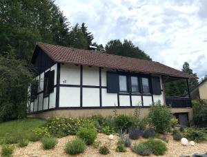 een wit en zwart huis met een tuin ervoor bij Ferienhaus Kolb in Hilders