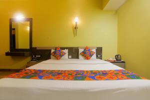 1 dormitorio con 1 cama blanca grande y espejo en FabHotel Elements Inn, en Patna