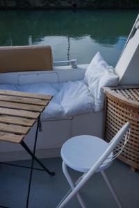 una sedia, un tavolo e un divano su una barca di Bâteau cocoon au bassin des lumières a Bordeaux