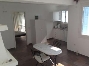 a kitchen with a table and chairs in a room at Antigoni Studios in Skiros