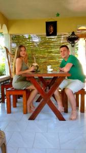Un uomo e una donna seduti a un tavolo da picnic di Rainforest Nature House a Deniyaya