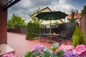 un patio con mesa y sombrilla en Villa Anna - FREE parking, en Gdansk