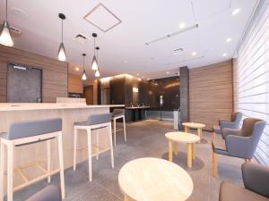 un vestíbulo con mesas y sillas y un bar en Hotel Comfybed Ginza, en Tokio