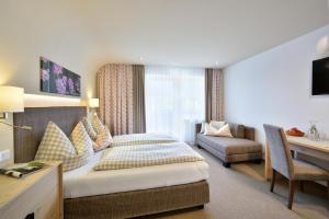 a hotel room with a bed and a desk at Hotel Hubertus in Neukirchen am Großvenediger