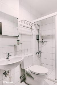 a white bathroom with a toilet and a sink at Tainan Haian Art Apartment in Tainan +67 photos