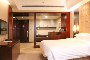 a bedroom with a large bed and a bathroom at Crowne Plaza Yantai Sea View, an IHG Hotel in Yantai
