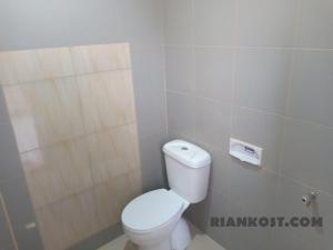 La salle de bains est pourvue de toilettes blanches. dans l'établissement Rian Kost - Hotel Penginapan Murah Pusat Kota Palembang, à Palembang