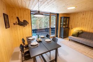 a living room with a table and a couch at Cosy Lodge Pokljuka in Goreljek