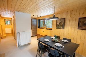 a dining room with a black table and chairs at Cosy Lodge Pokljuka in Goreljek