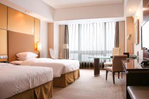 pokój hotelowy z 2 łóżkami i stołem w obiekcie Crowne Plaza Yantai Sea View, an IHG Hotel w mieście Yantai
