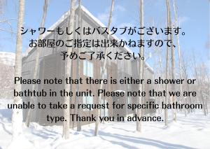 a sign in the snow with writing on it at SnowDog Village in Niseko